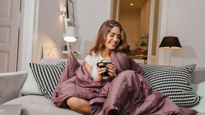woman on couch with weighted blanket
